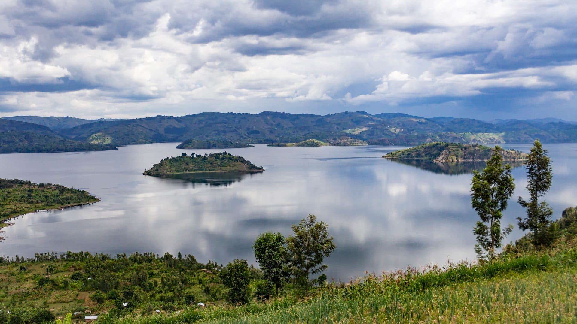 Lake Kivu mit kleinen Inseln im smaragdgrünen Wasser, umgeben von den bewaldeten Hügeln Ruandas – Westafrikas schönster Bergsee an der Grenze zur Demokratischen Republik Kongo