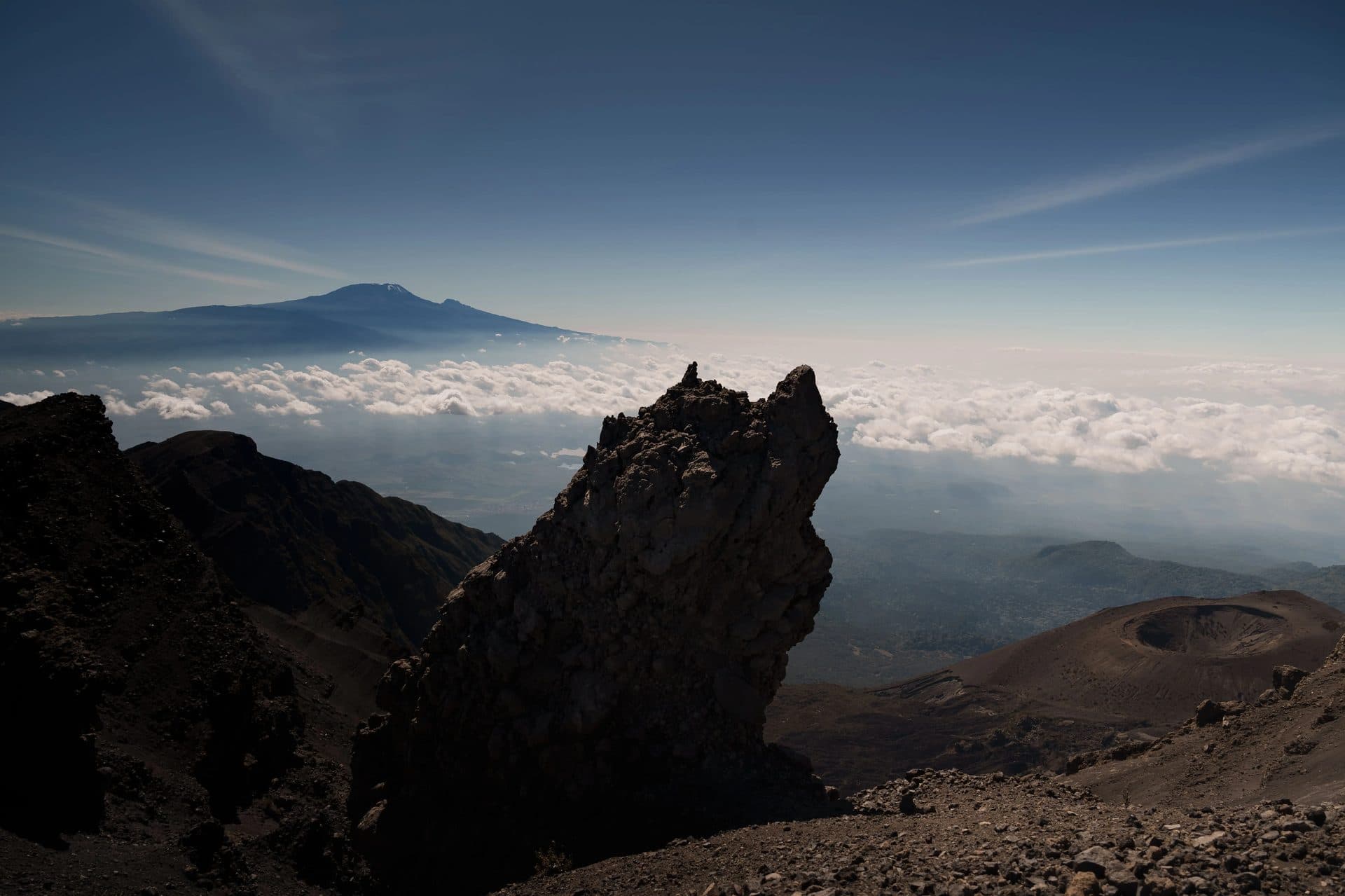 Blick vom Mount Meru auf den schneebedeckten Kilimandscharo über dem Wolkenmeer