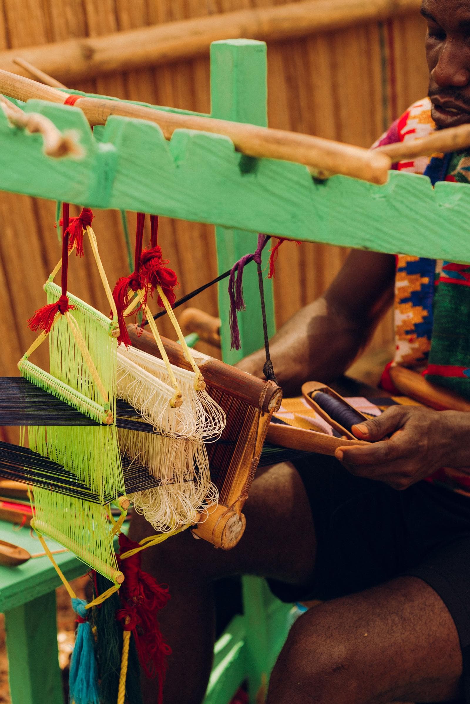 Kente-Weber an einem traditionellen Webstuhl in Bonwire, Ghana