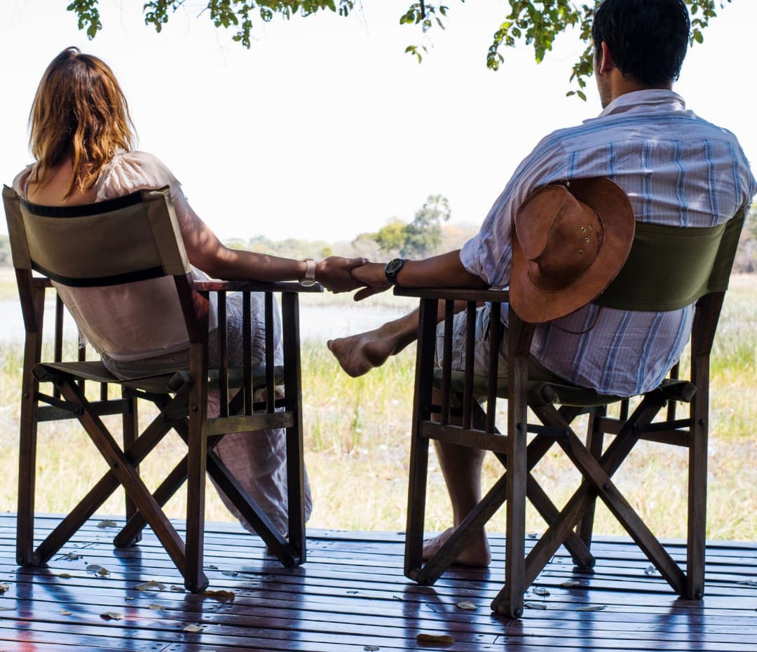 Paar genießt die Aussicht von der privaten Lodge-Terrasse während der Flitterwochen-Safari