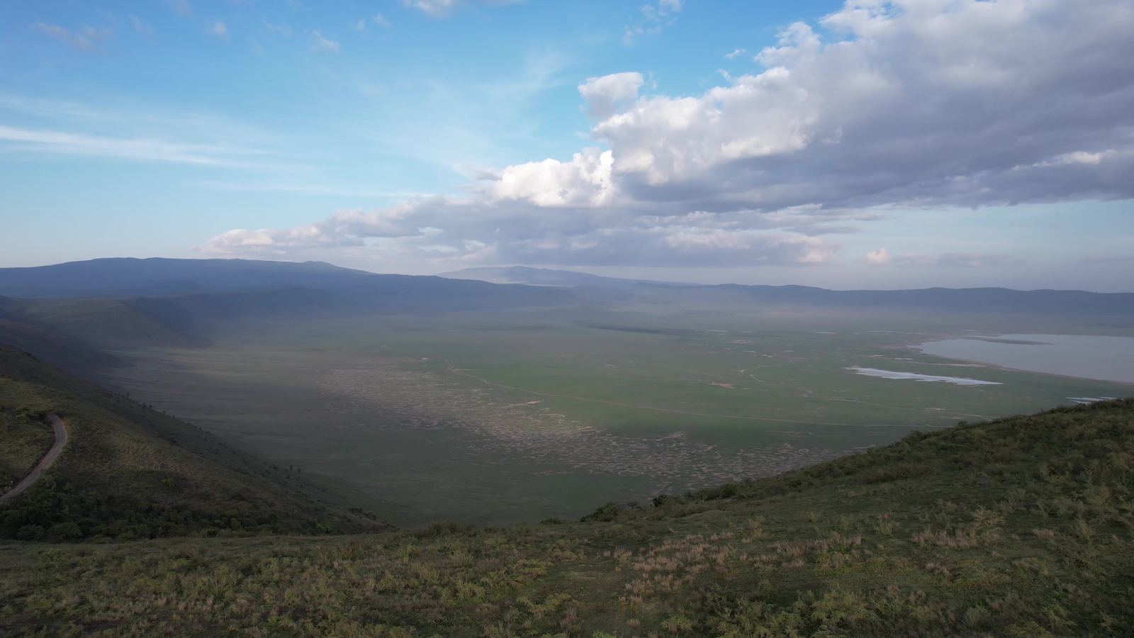 Drohnenblick vom Kraterrand über den Ngorongoro-Krater mit dem Magadi-See und Wolken