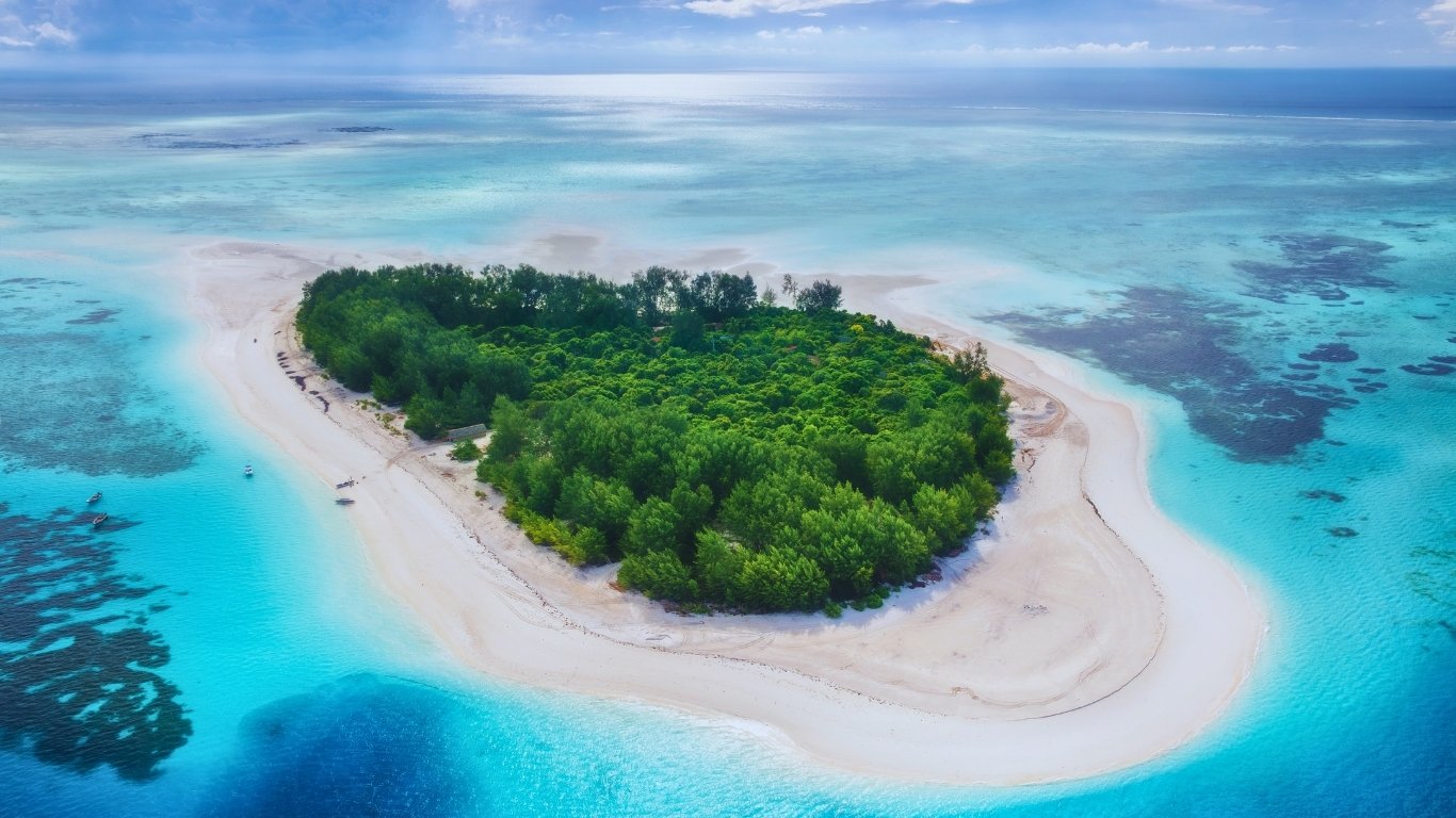 Luftaufnahme einer bewaldeten Sandbank-Insel vor Sansibar